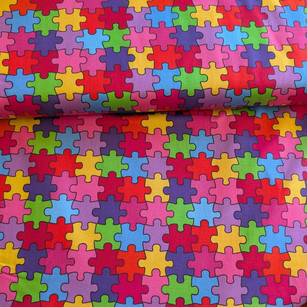 Multicolour Autism Awareness puzzle piece cotton fabric with red, blue, green, yellow, and purple jigsaw pattern