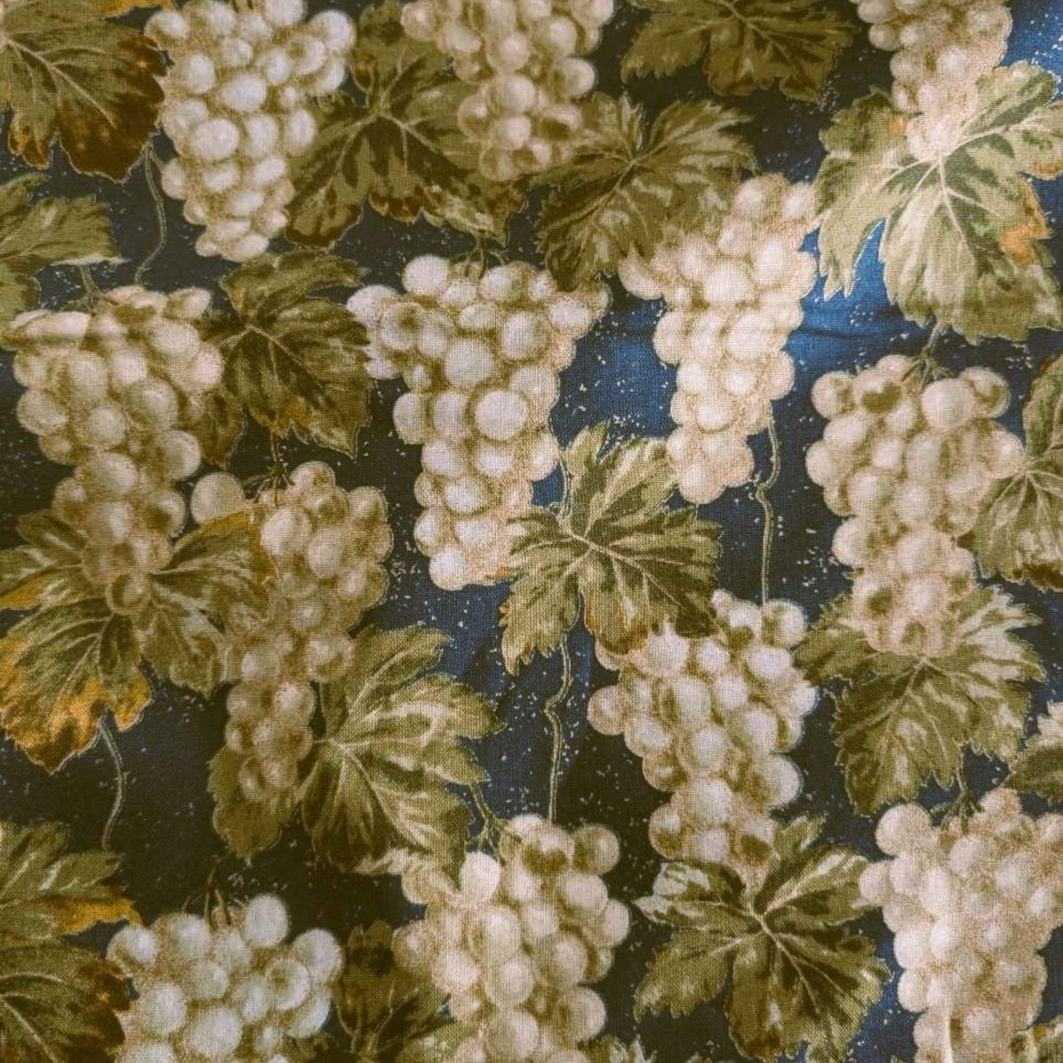 Nature’s Harvest cotton fabric by Robert Kaufman featuring green grape clusters and vine leaves on green with gold accents