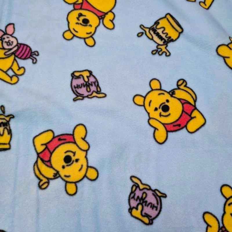 Winnie the Pooh anti-pill fleece on light blue with honey jars. Soft, cozy fabric for blankets, scarves, and crafts.