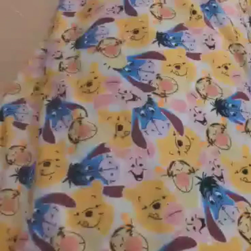 Video of Cream minky fabric with Winnie the Pooh, Piglet, Tigger, and Eeyore faces in an allover print – Camelot brand