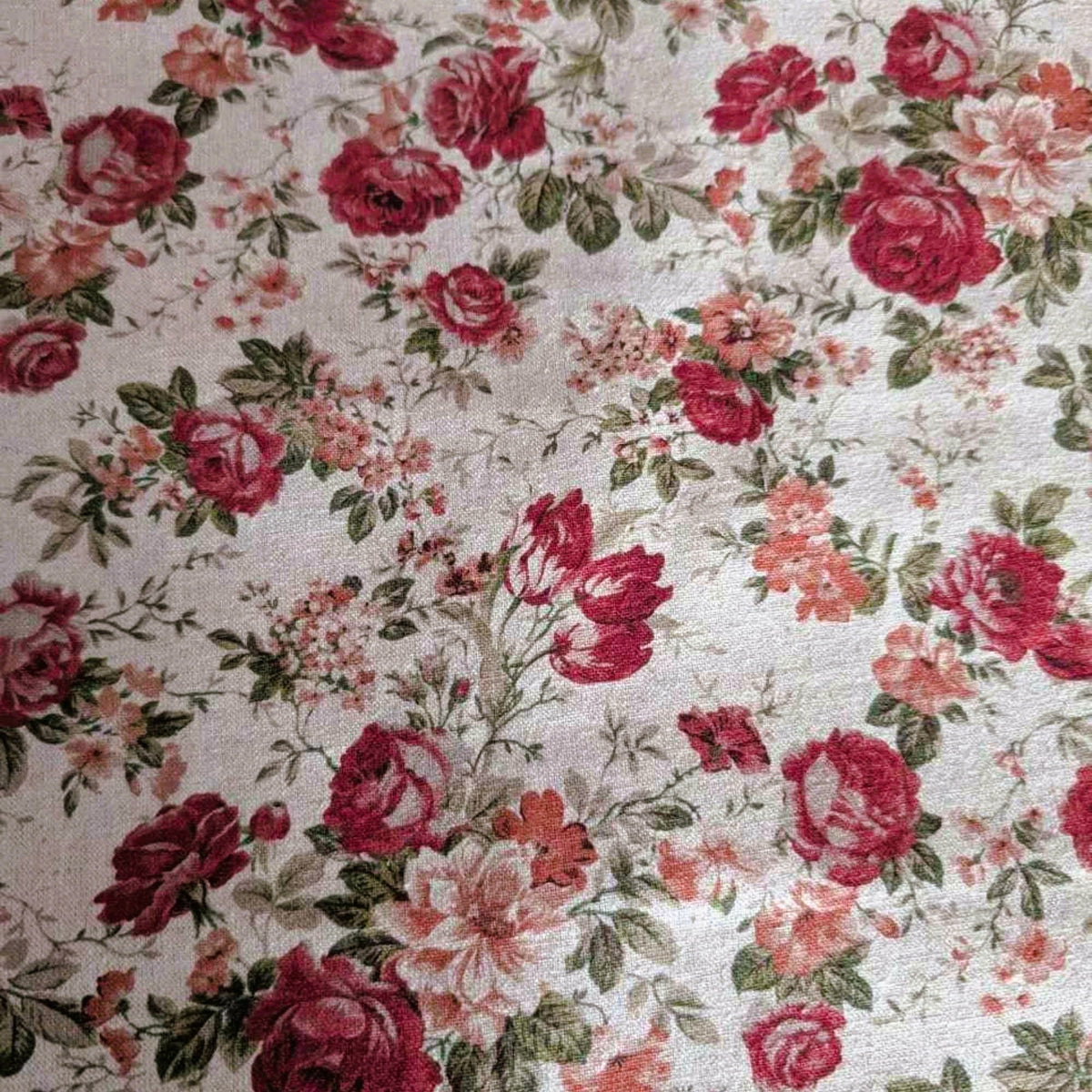 Vintage-inspired cotton flax fabric with red roses and green leaves on a natural beige background – ideal for home décor, quilting, and crafts
