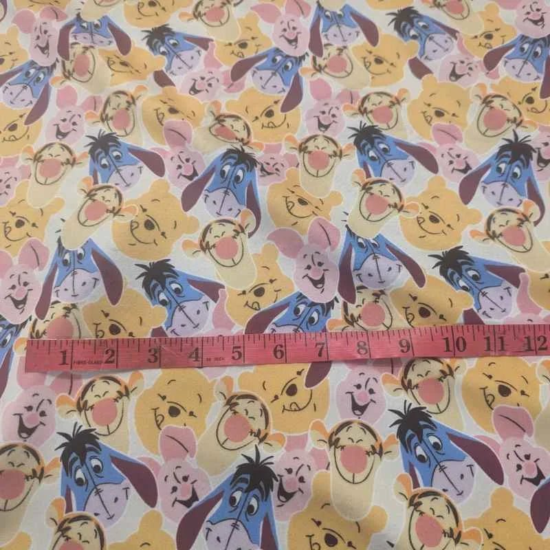 Cream minky fabric with Winnie the Pooh, Piglet, Tigger, and Eeyore faces in an allover print – Camelot brand