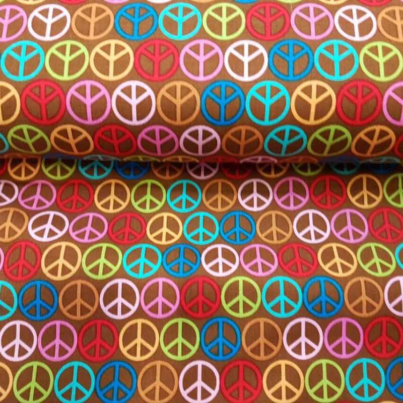 Riley Blake Feeling Groovy cotton fabric with colorful peace signs on brown background.