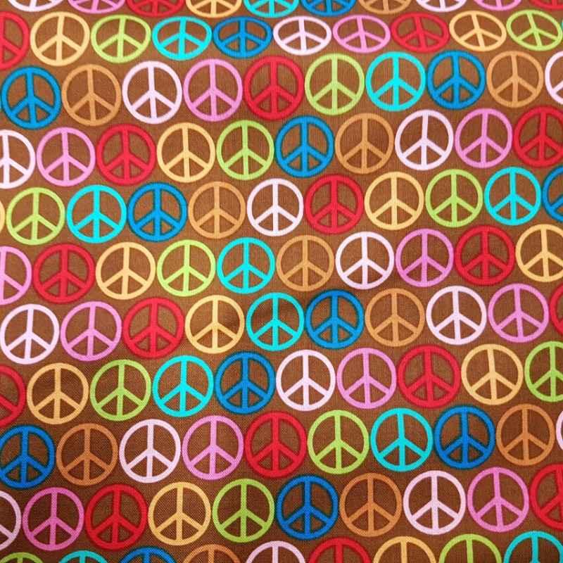 Riley Blake Feeling Groovy cotton fabric with colorful peace signs on brown background.