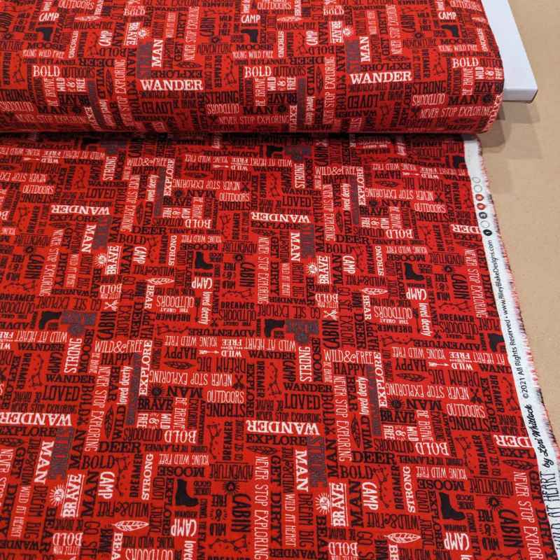 Red cotton flannel with bold white and black adventure-themed text including “Wander,” “Camp,” and “Never Stop Exploring” – 44 inches wide brushed cotton