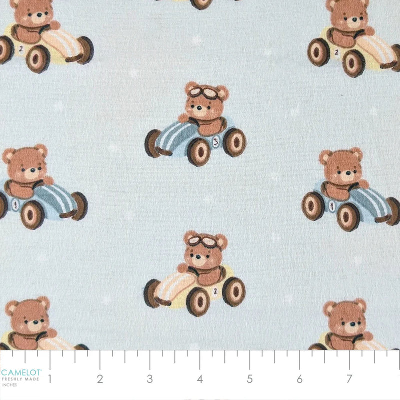 Camelot Fabrics Racing Teddies light blue cotton flannel fabric featuring teddy bears driving vintage toy race cars from the Fleece and Flannel 2026 Collection.