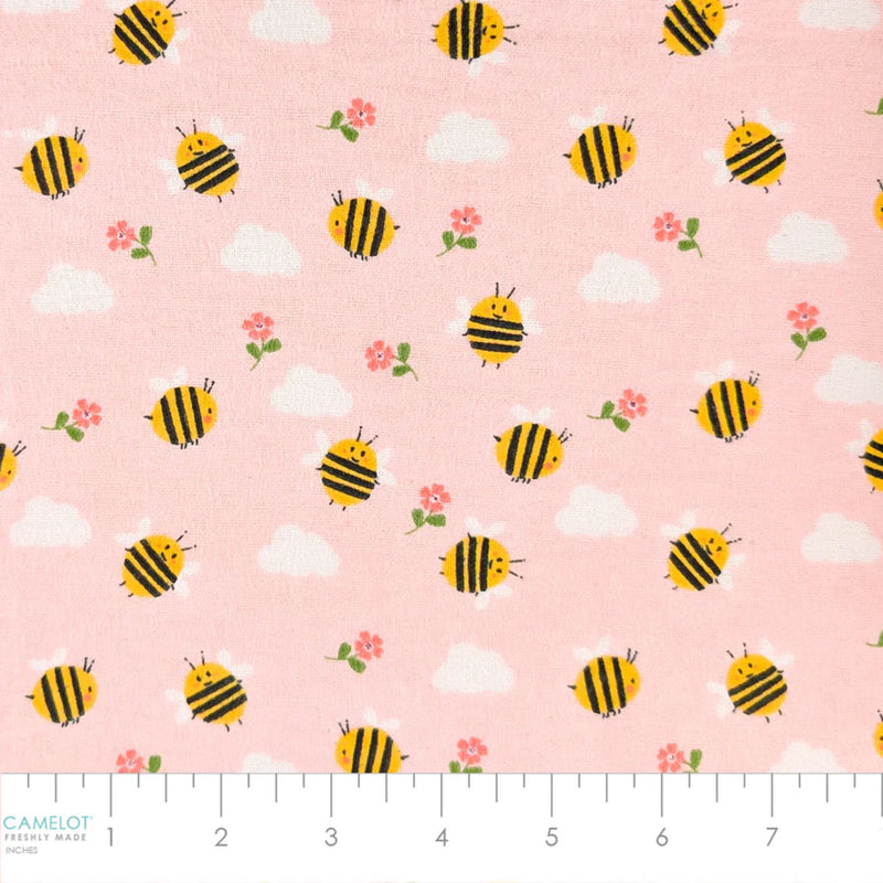 Camelot Fabrics Bumble Bees pink cotton flannel fabric featuring yellow bees, white clouds, and pink flowers from the Fleece and Flannel 2026 Collection.