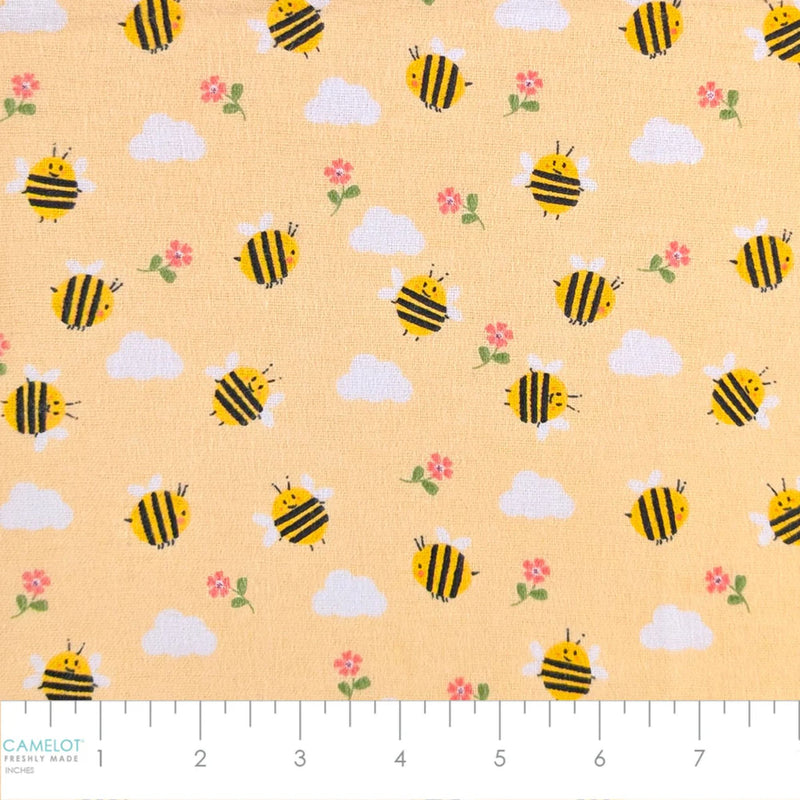 Camelot Fabrics Bumble Bees peach cotton flannel fabric featuring cheerful yellow bees, fluffy clouds, and pink flowers from the Fleece and Flannel 2026 Collection.
