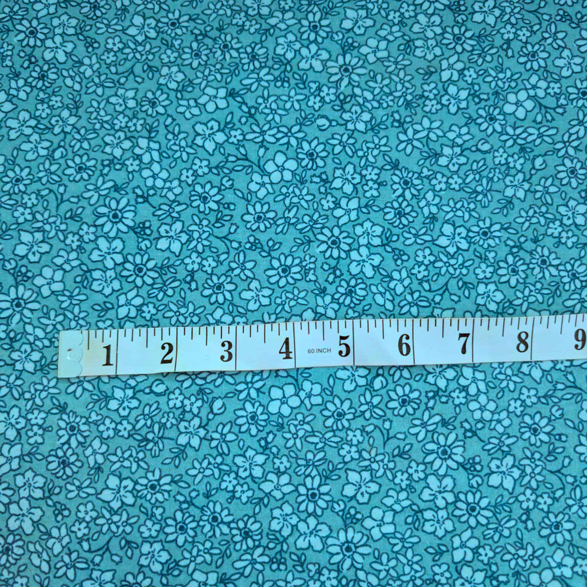 108 inch wide brushed cotton flannel wideback with aqua floral print for seamless quilt backing with tape measure