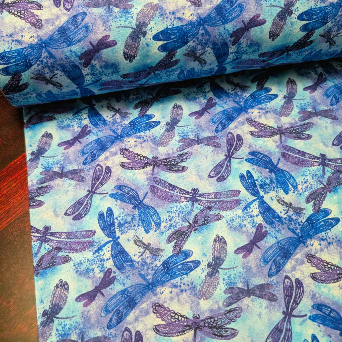 Blue dragonfly cotton flannel fabric with watercolor background in blue and purple tones, brushed for softness, 44 inches wide, OEKO-TEX certified.