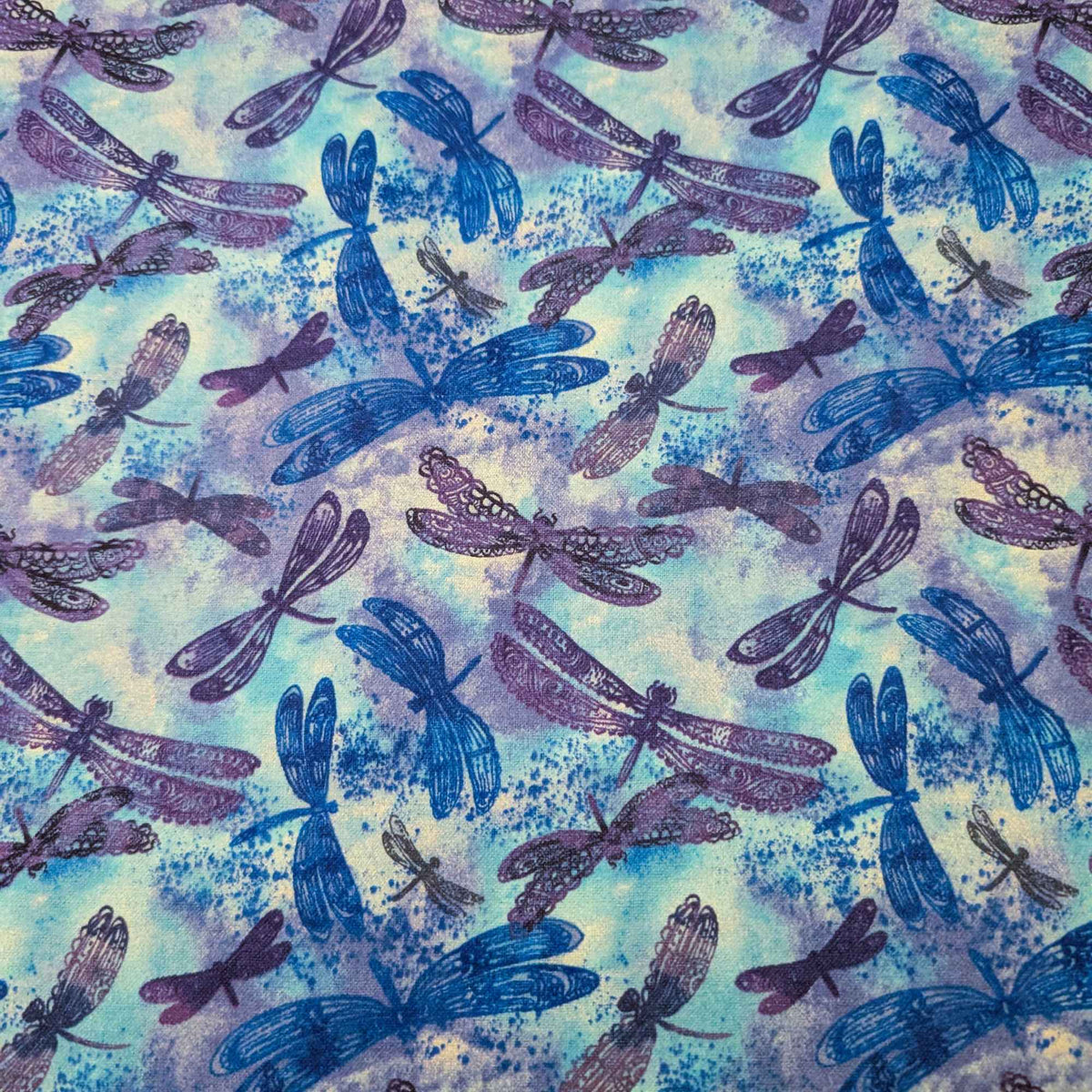 Blue dragonfly cotton flannel fabric with watercolor background in blue and purple tones, brushed for softness, 44 inches wide, OEKO-TEX certified.