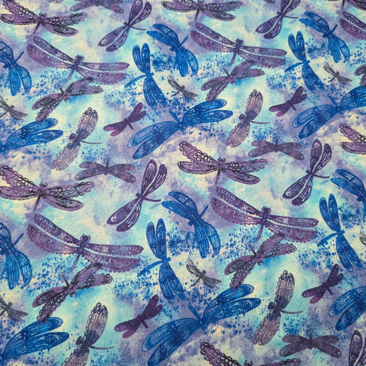 Blue dragonfly cotton flannel fabric with watercolor background in blue and purple tones, brushed for softness, 44 inches wide, OEKO-TEX certified.