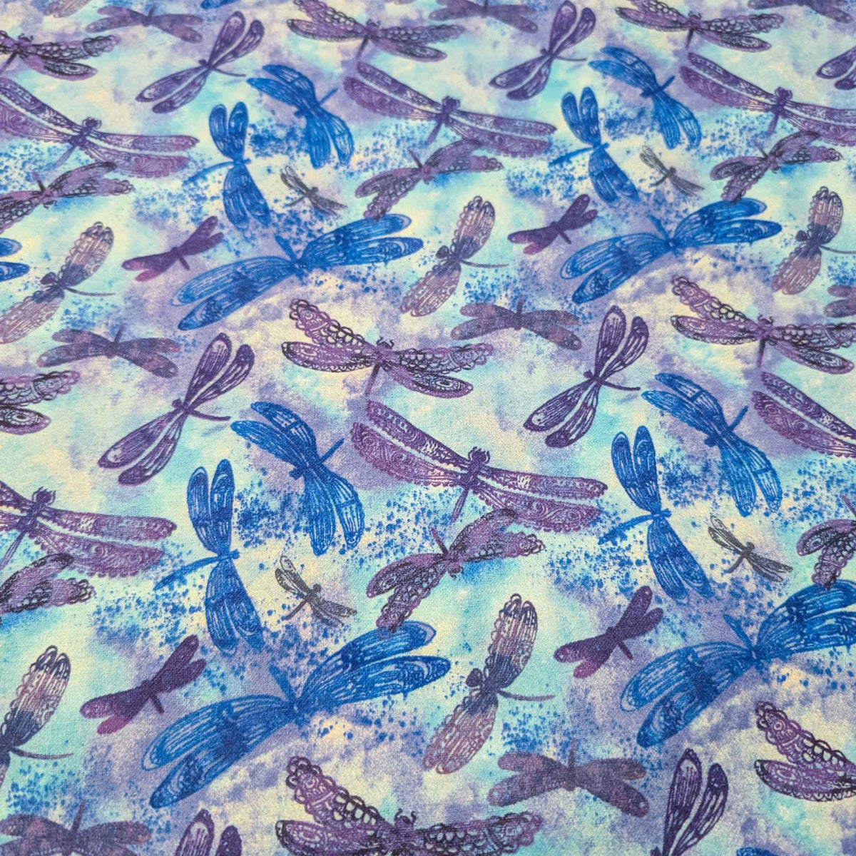 Blue dragonfly cotton flannel fabric with watercolor background in blue and purple tones, brushed for softness, 44 inches wide, OEKO-TEX certified.
