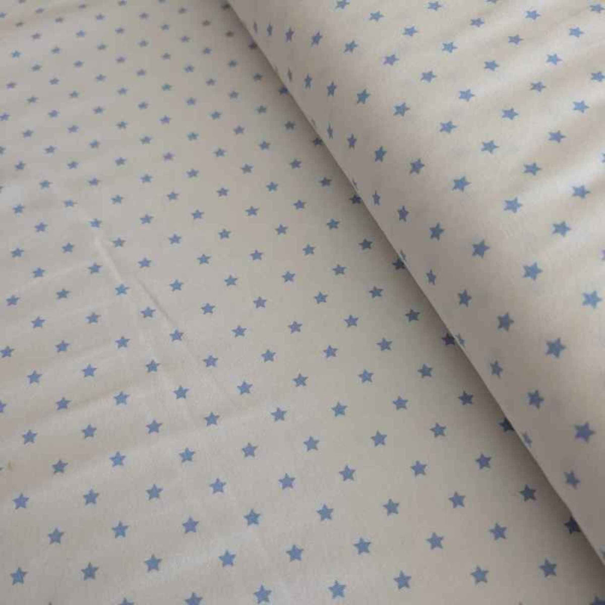 Organic cotton jersey knit fabric with blue star pattern on white background