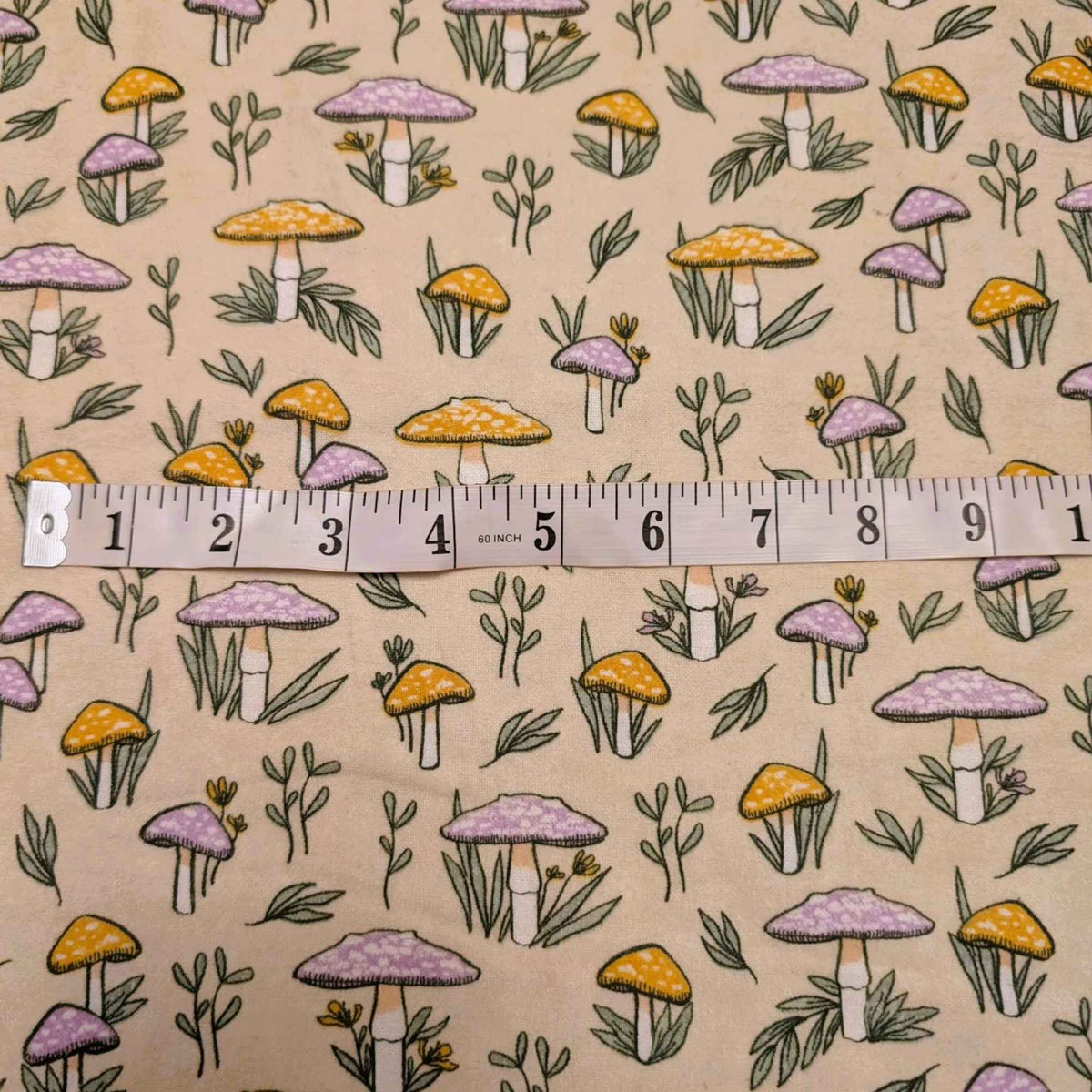 108 inch wide brushed cotton flannel wideback with mushroom and leaf print on cream background for quilt backing