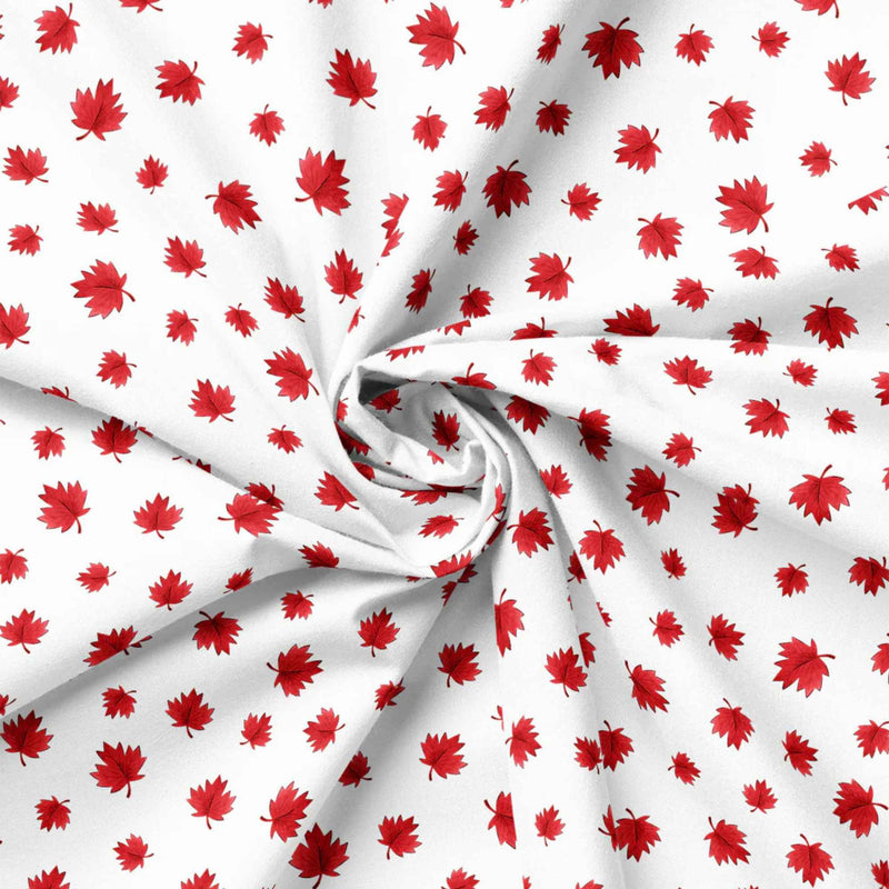 "White cotton fabric with scattered red maple leaves by Camelot Fabrics"