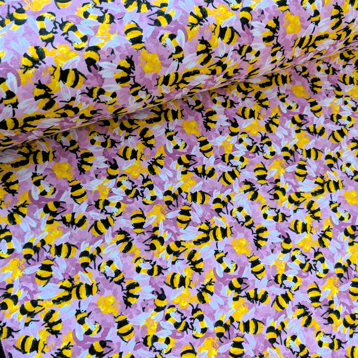 Cotton flannel fabric with yellow and black bees on a pink purple background, brushed for softness, Oeko-Tex certified, 44" wide.
