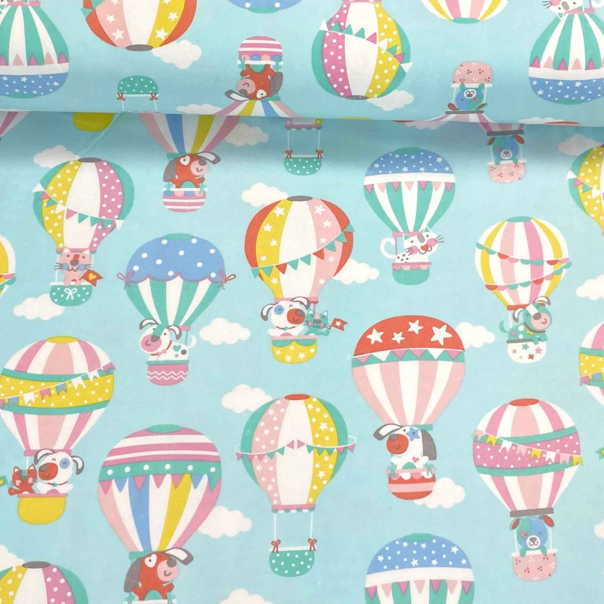 Cotton flannel fabric with pastel hot air balloons carrying dogs and cats in a light blue sky with clouds – whimsical kids’ fabric