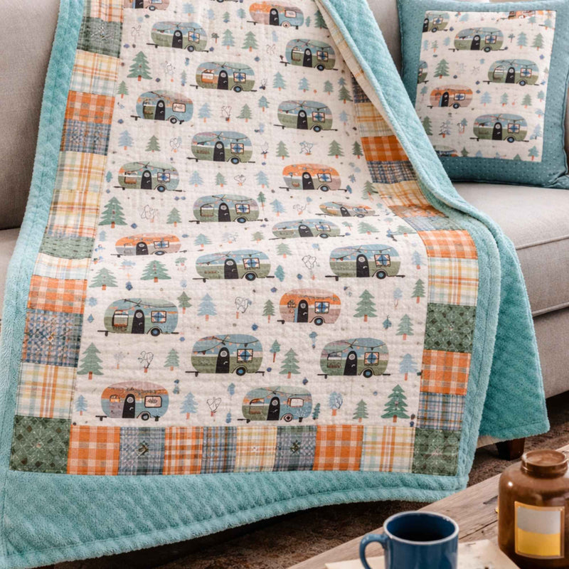 Cozy camper-themed quilt on sofa