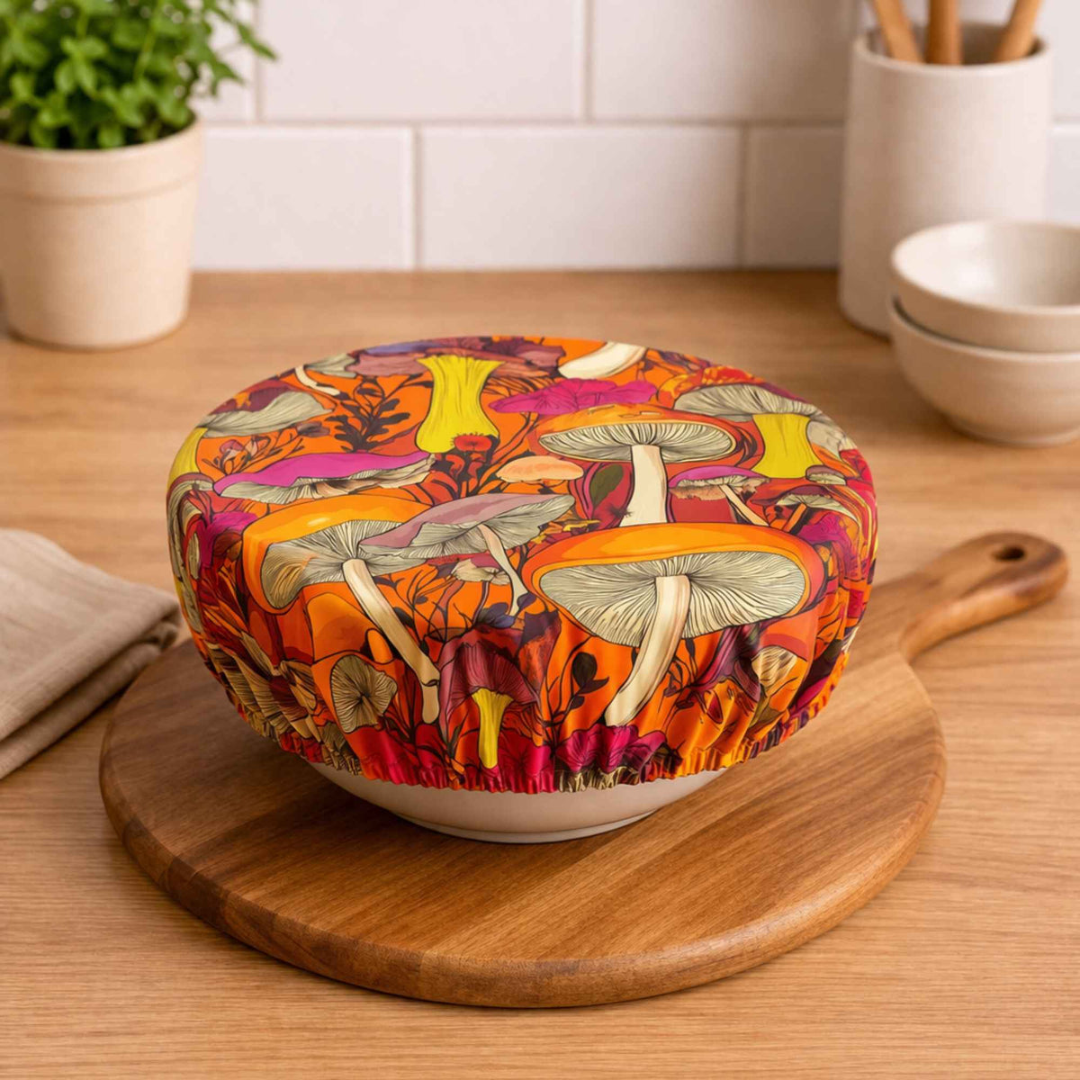 Bowl cover made with bright retro mushroom print food safe waterproof polyurethane laminate fabric with orange background and pink, yellow and coral mushrooms.