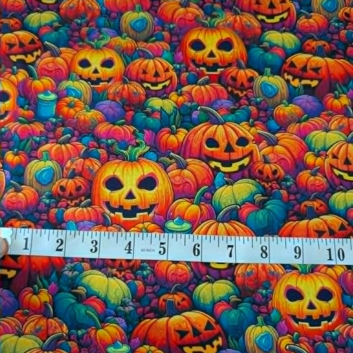 Bright Frights Halloween cotton fabric with colorful neon pumpkins glowing jack o lanterns and autumn foliage by Robert Kaufman