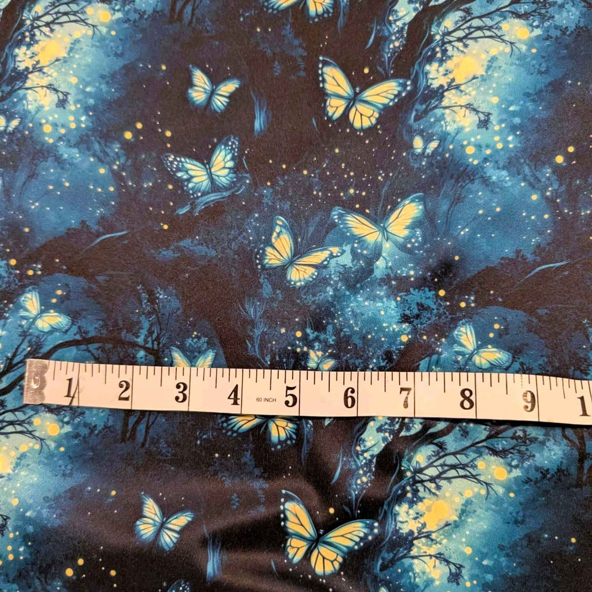 Enchanted Butterfly Forest exclusive waterproof PUL fabric with glowing butterflies and fireflies among dark teal woodland trees