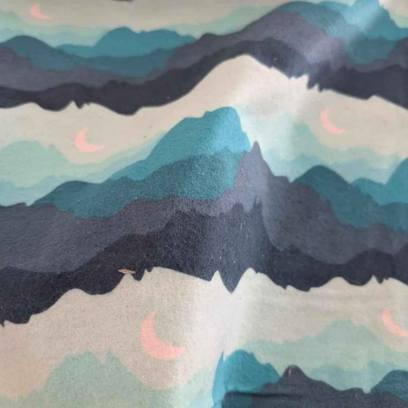 Teal, navy and grey mountain print flannel fabric with pink crescent moons