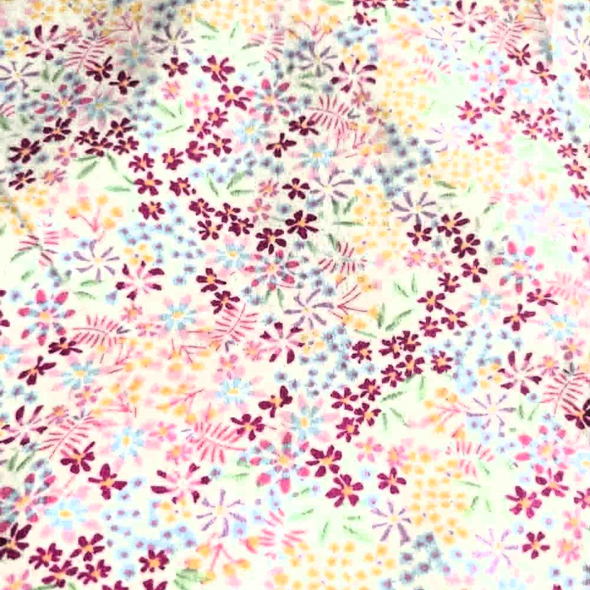Double brushed flannel fabric featuring pastel wildflowers and delicate floral sprigs in pink, lavender, blue, yellow, and green on a white background.