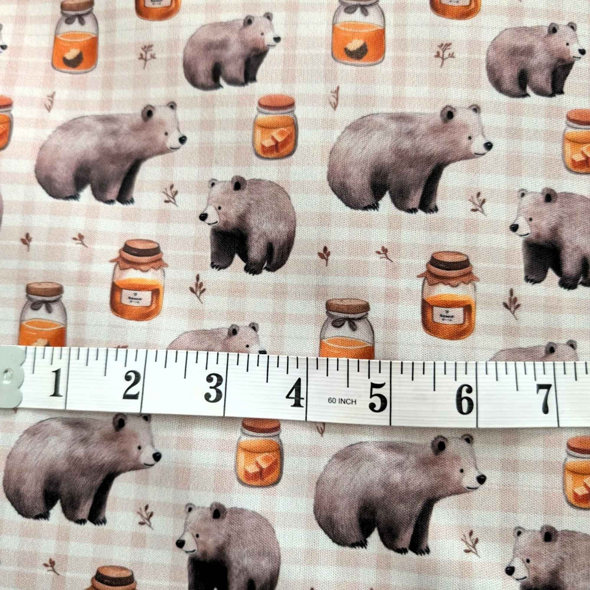 Honey Bear exclusive waterproof PUL fabric with brown bears, golden honey jars and botanical sprigs on a cream checked background