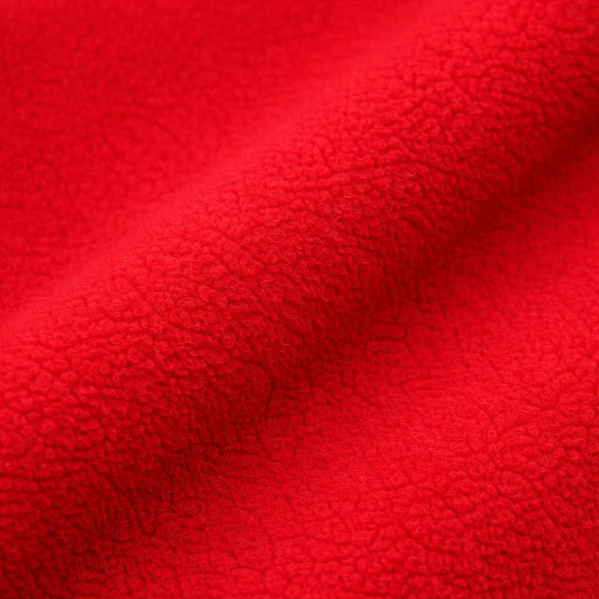 Close-up texture of cardinal red anti-pill polar fleece fabric – soft fuzzy polyester fleece material.