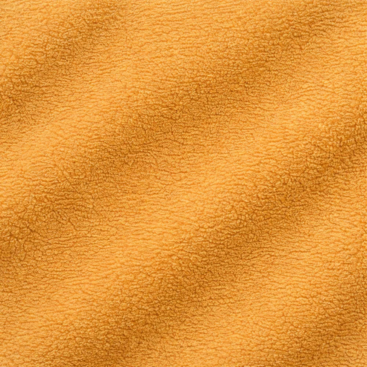 Close-up texture of honey anti-pill polar fleece fabric – soft fuzzy polyester fleece material