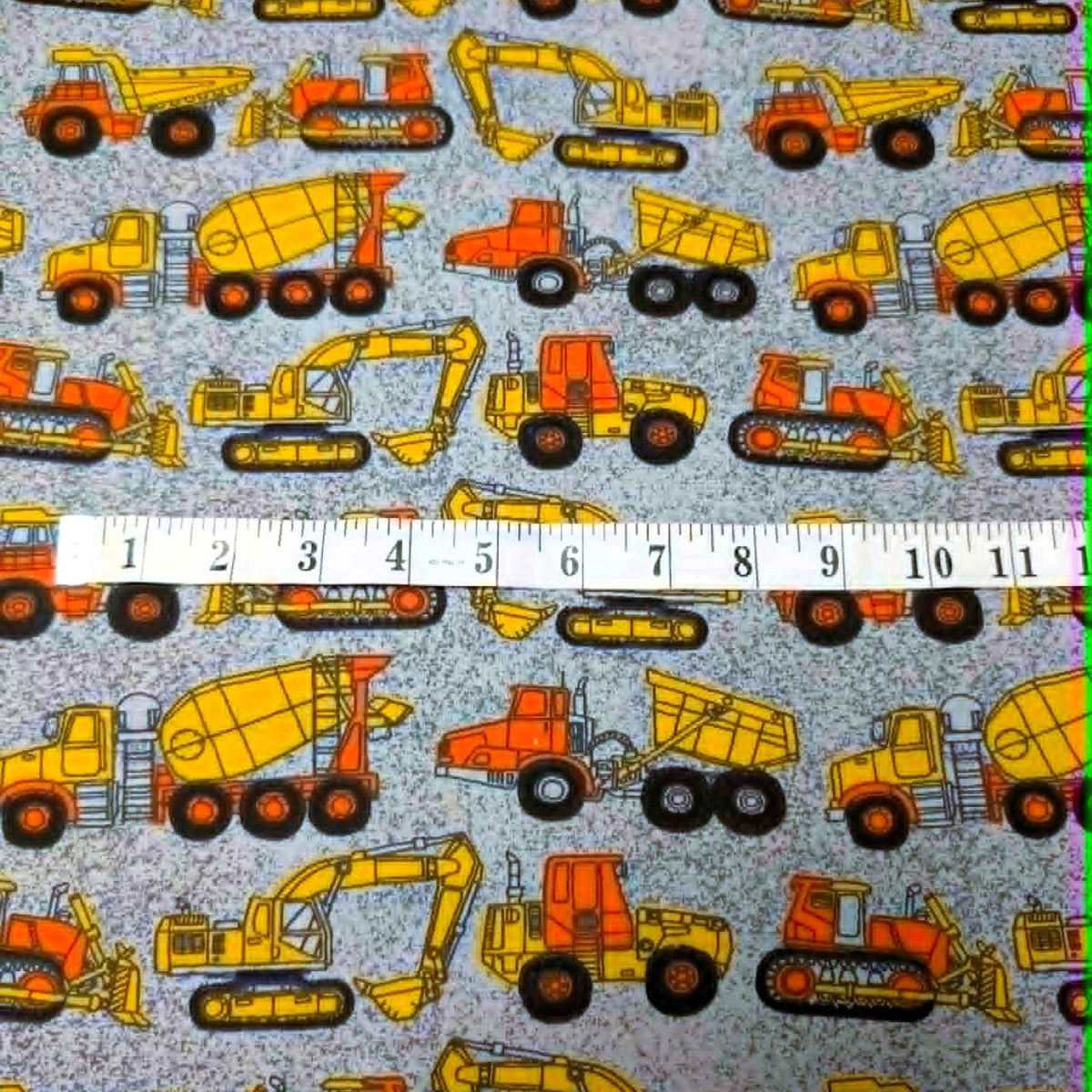 Construction vehicles quilting cotton fabric with dump trucks, excavators, bulldozers, and cement mixers in yellow and orange