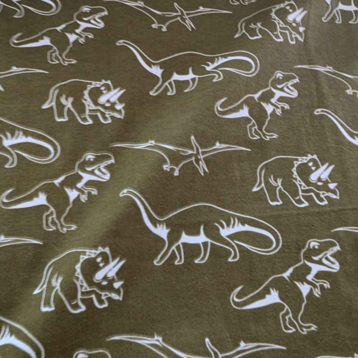 Glow in the dark dinosaur cotton flannel fabric with white dinosaur silhouettes on dark background, soft brushed quilting fabric
