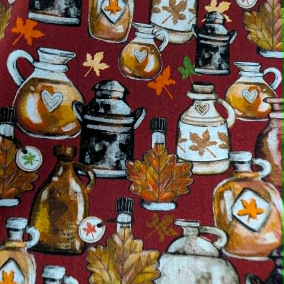 Autumn maple syrup jugs and fall leaves cotton fabric on red background with rustic harvest theme