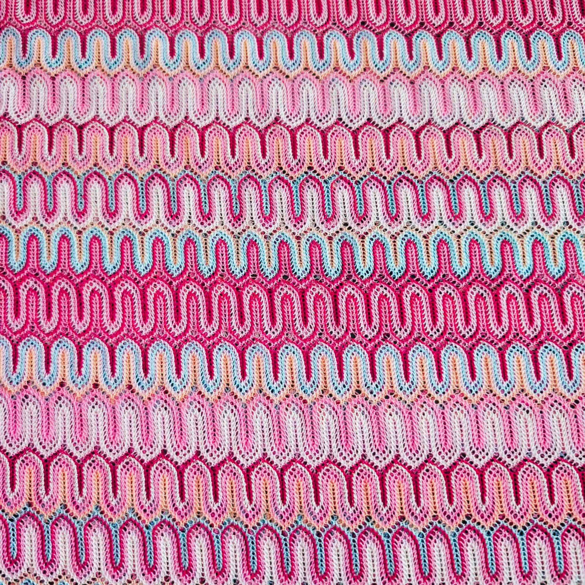 Missoni style pink zigzag wave stretch jersey knit fabric with fuchsia ivory and aqua pattern close-up texture