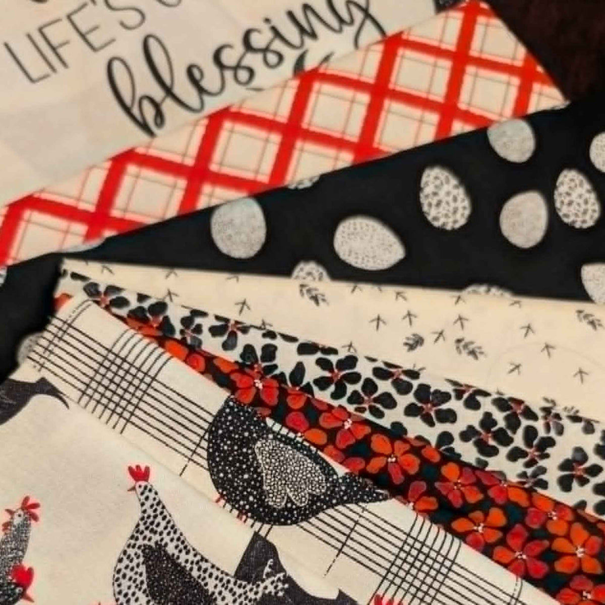 Hen House fabric bundle by Camelot Fabrics featuring chicken prints, farmhouse plaids, egg patterns, floral coordinates, and coordinating quilting panel in black white and red