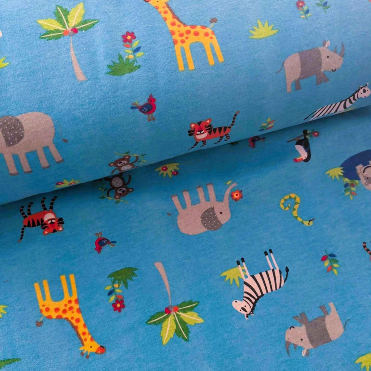 Blue fabric with a colorful safari animal print, featuring giraffes, elephants, zebras, monkeys, and tropical leaves.