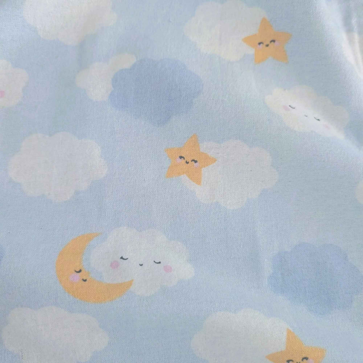Light blue fabric with a repeating pattern of smiling yellow stars, white and light blue clouds, and a crescent moon with sleeping faces.