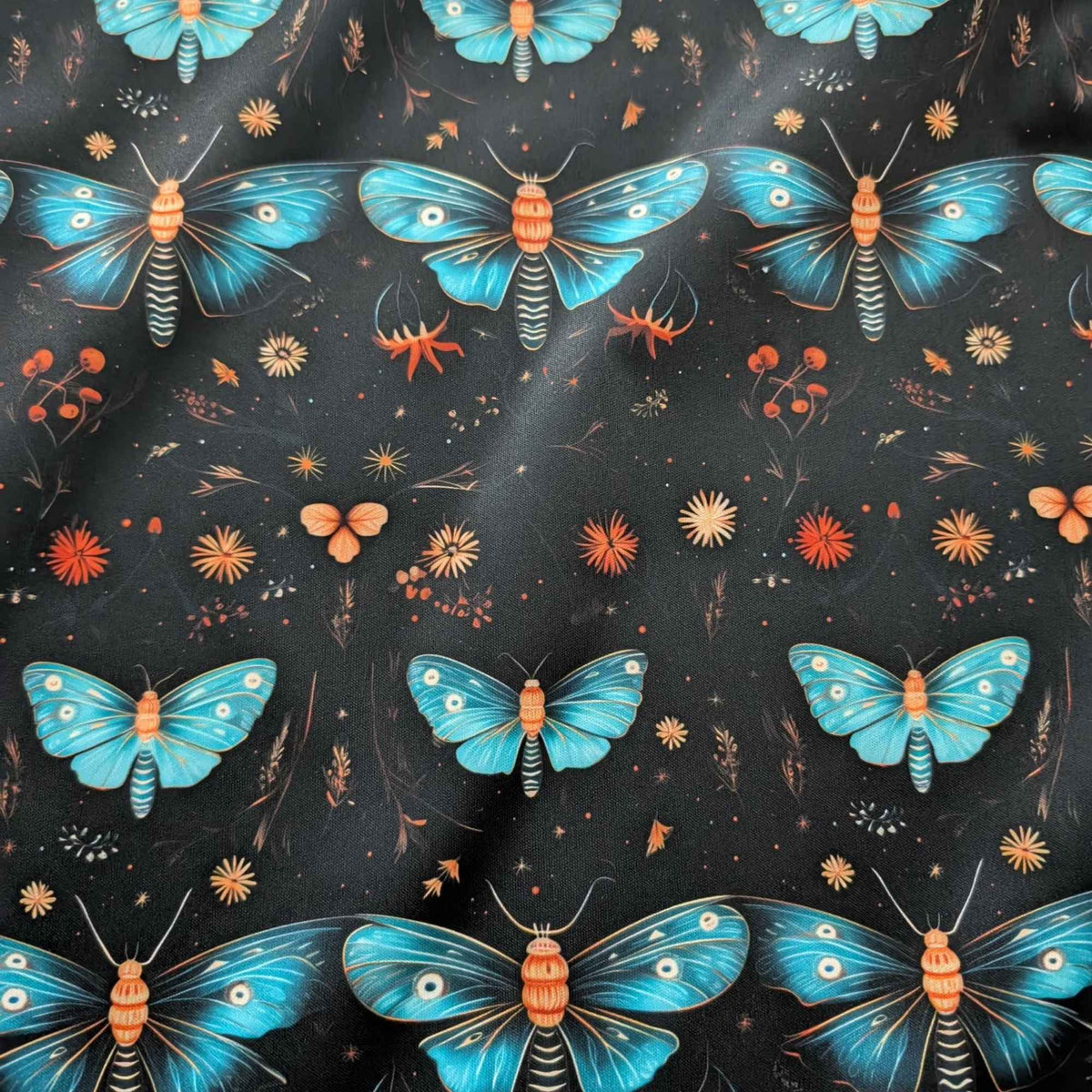 Midnight Blue Moths and Wildflowers exclusive waterproof PUL fabric with turquoise moths and orange flowers on a black background