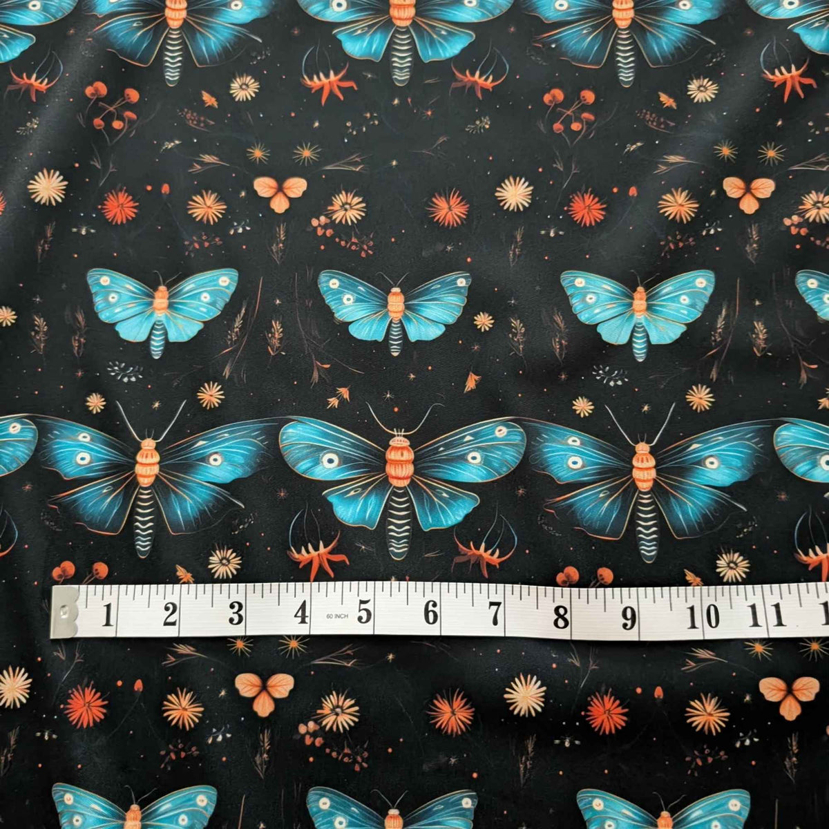 Midnight Blue Moths and Wildflowers exclusive waterproof PUL fabric with turquoise moths and orange flowers on a black background