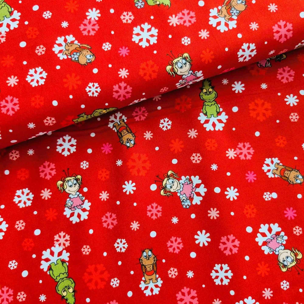 Little Grinch cotton fabric with Grinch characters and snowflakes on red