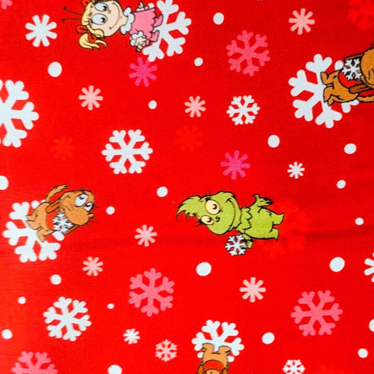 Little Grinch cotton fabric with Grinch characters and snowflakes on red