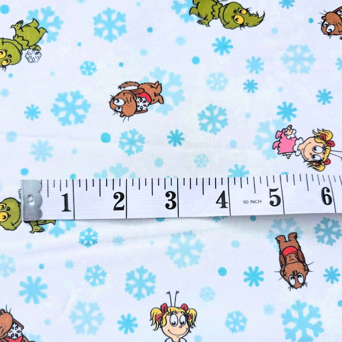 Little Grinch cotton fabric with Grinch characters and aqua snowflakes on white