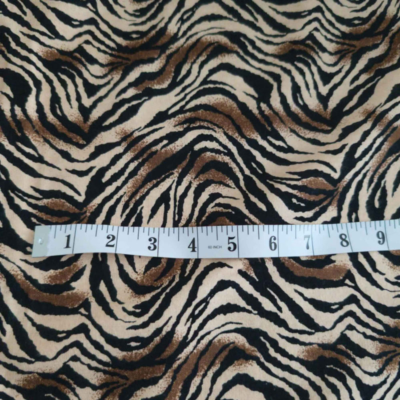 Tiger stripe cotton flannel fabric featuring wavy black stripes and brown accents on a cream background.