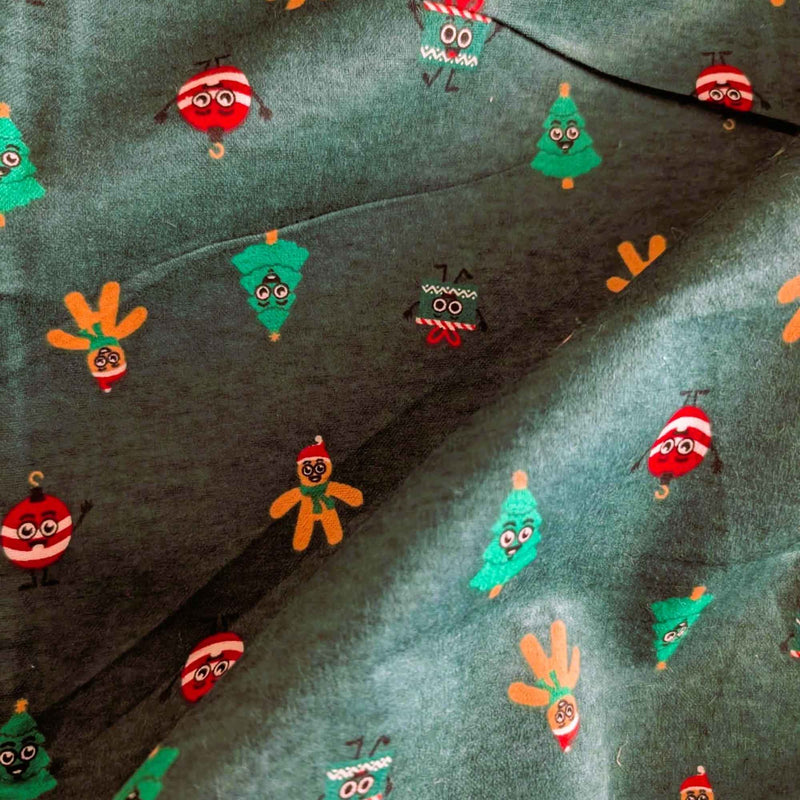 Dark green cotton flannel with smiling Christmas trees, gingerbread figures, red and white ornaments, and gift boxes.