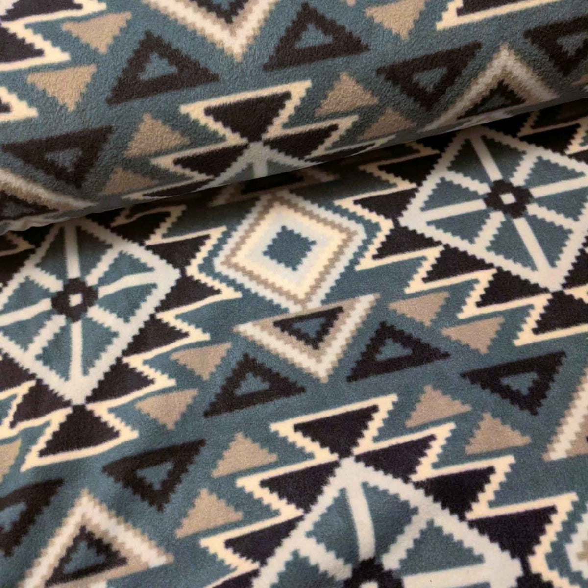 To the Mountains denim blue fleece by Camelot with navy, pale blue, grey and white geometric diamonds, triangles and zigzags.