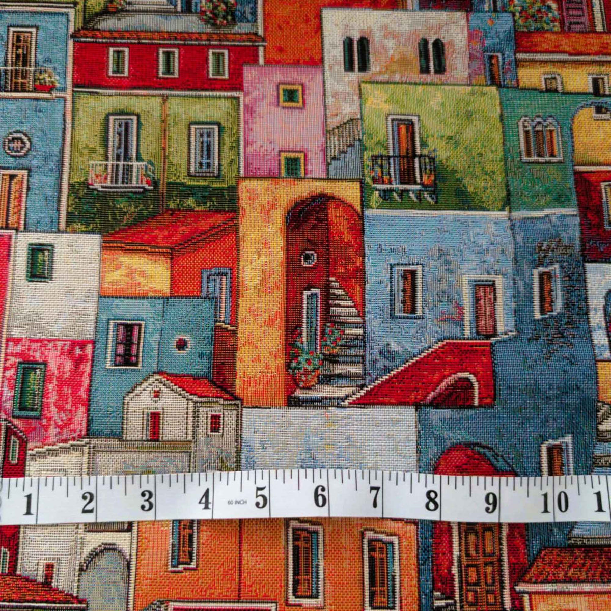 Mediterranean village Gobelin tapestry fabric featuring colourful houses, tiled roofs, balconies, arched doorways and winding stairways.