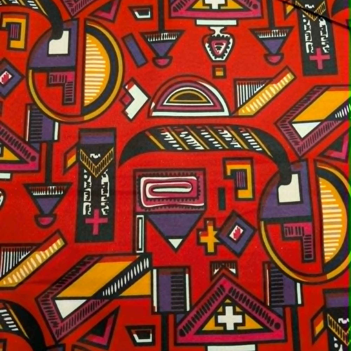 African-inspired geometric tribal double brushed flannel fabric featuring colorful abstract symbols and ethnic geometric patterns on a red background.
