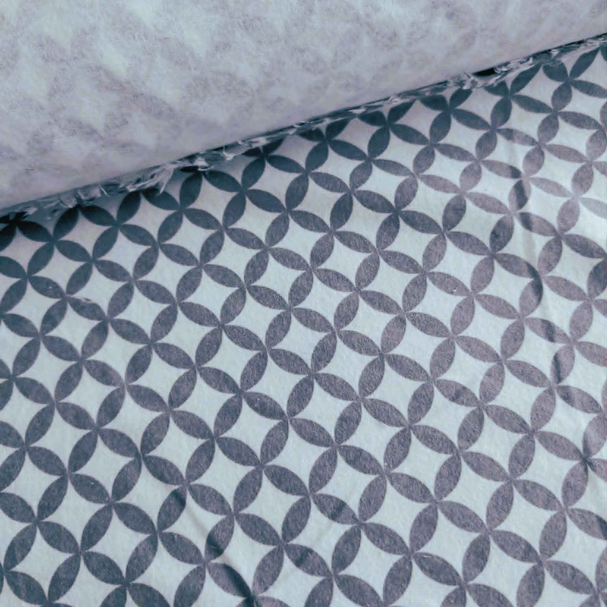 Grey interlocking rings geometric pattern on white 100% cotton flannel fabric, brushed on both sides and ideal for quilting, bedding, blankets, and sewing projects.