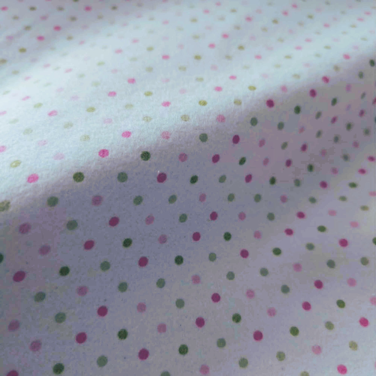 Robert Kaufman Cozy Cotton flannel fabric featuring scattered pink and green dots on a white background, soft two-ply cotton flannel for quilting and sewing projects.